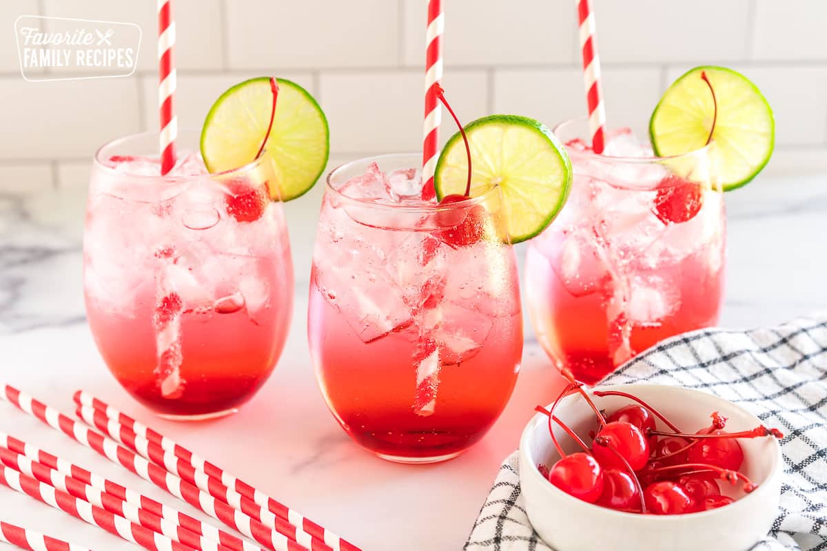 three shirley temples garnished with cherries and lime