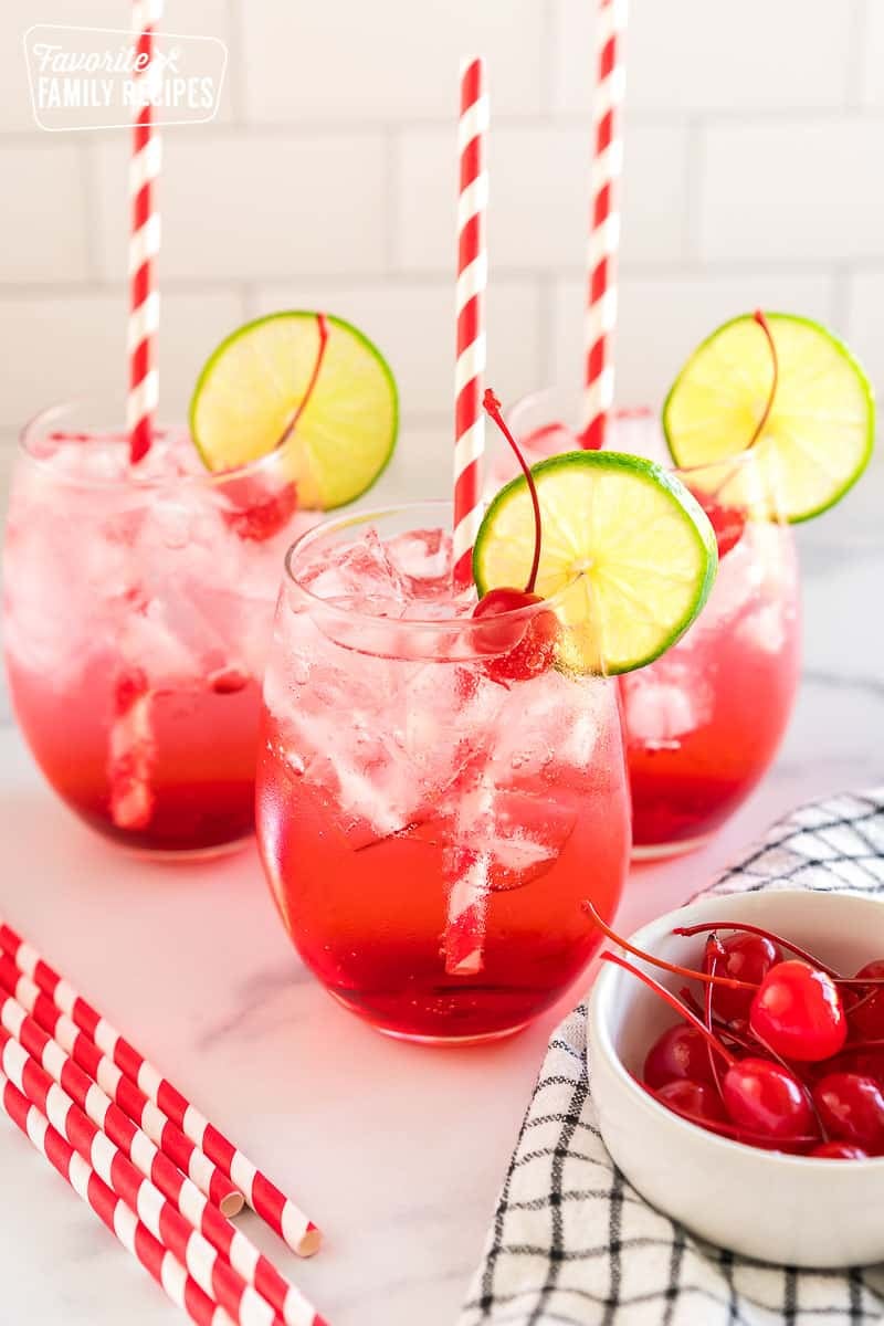 three shirley temples garnished with cherries and lime