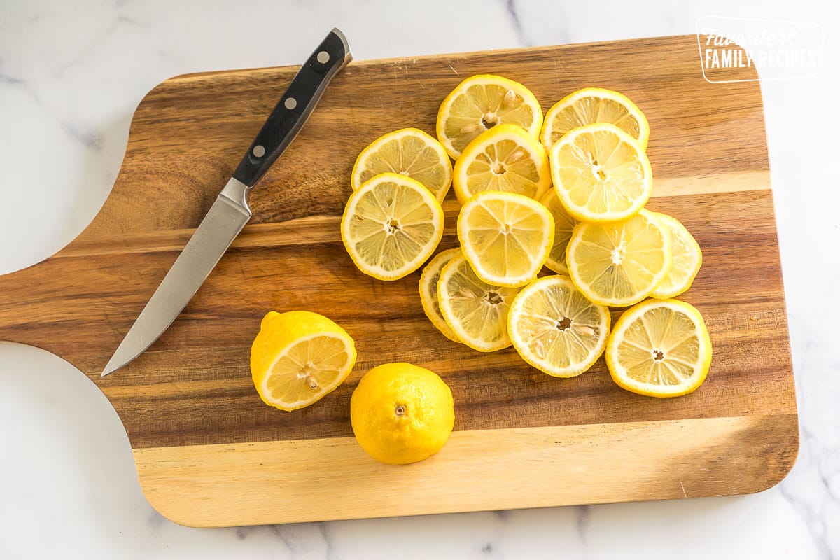 lemon slices on a cutting board with a knife
