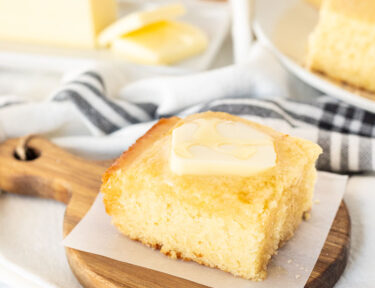 Cornbread slice with butter and honey on top.