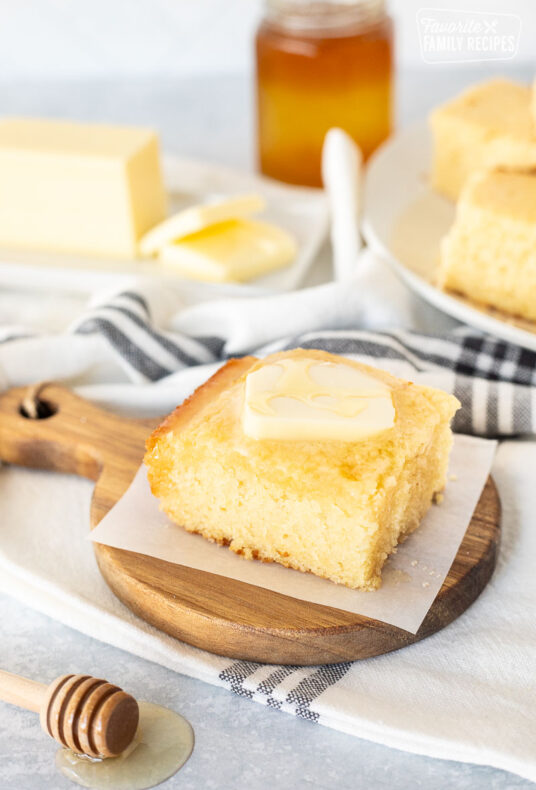 Cornbread slice with butter and honey on top.
