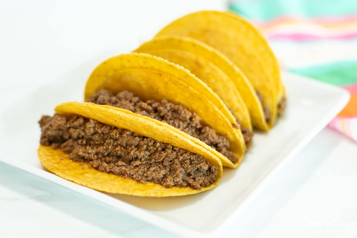 A skillet with seasoned Taco Bell meat with a serving spoon