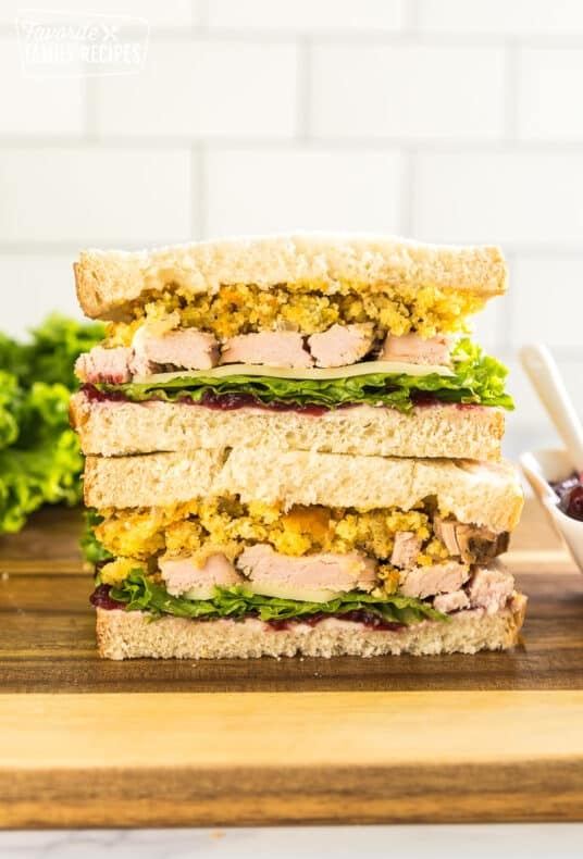 A Thanksgiving leftover pilgrim sandwich cut in half with one half stacked on the other