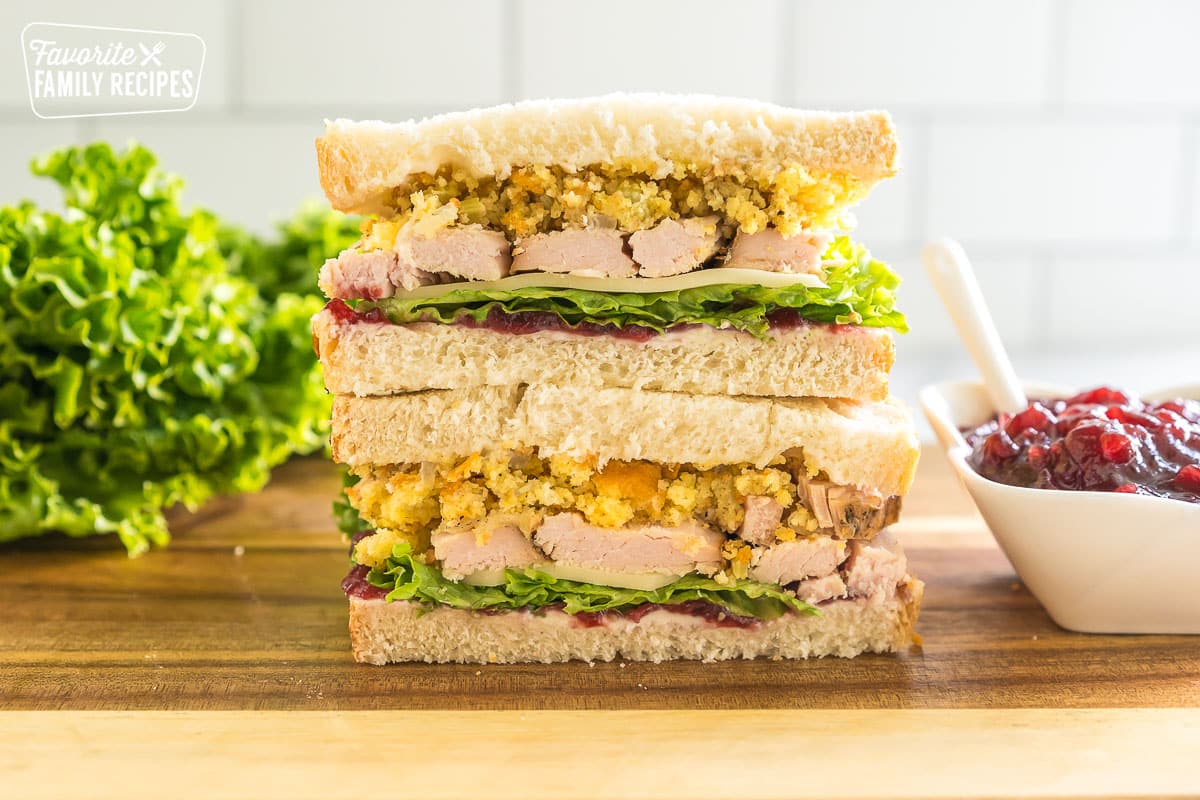 A Thanksgiving leftover pilgrim sandwich cut in half with one half stacked on the other