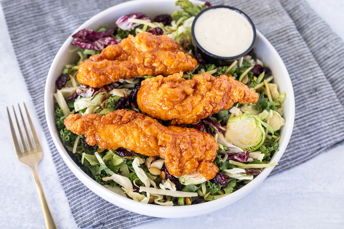 Salad topped with Winger's Sticky Fingers and Freakin Amazing Sauce. Ranch dressing on the side.