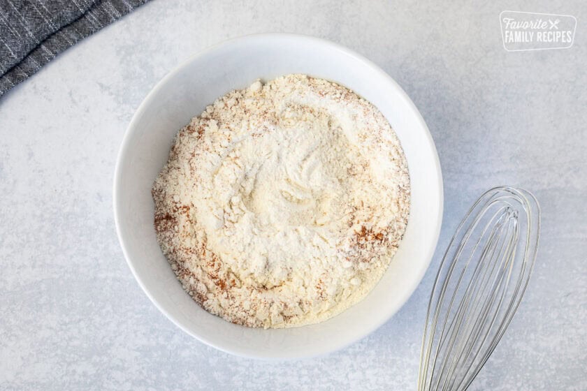 Bowl of flour mixture and whisk on the side.