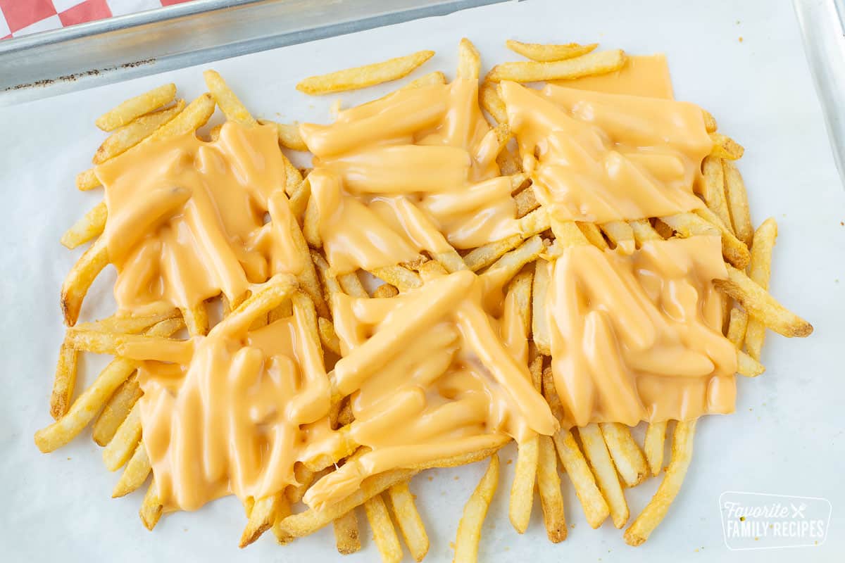Fries on a pan with melted American cheese over the top
