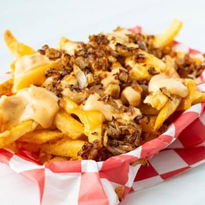 A side view of a basket of animal style fries