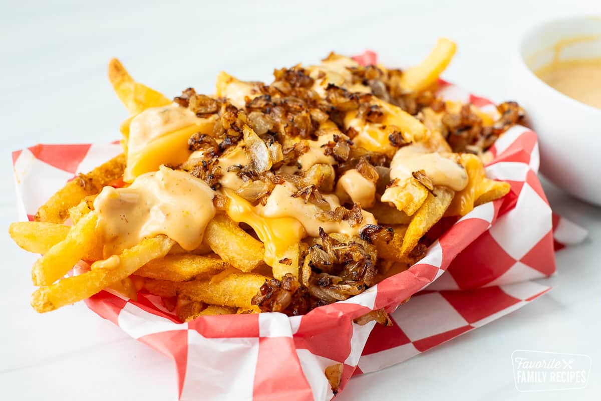 A side view of a basket of animal style fries