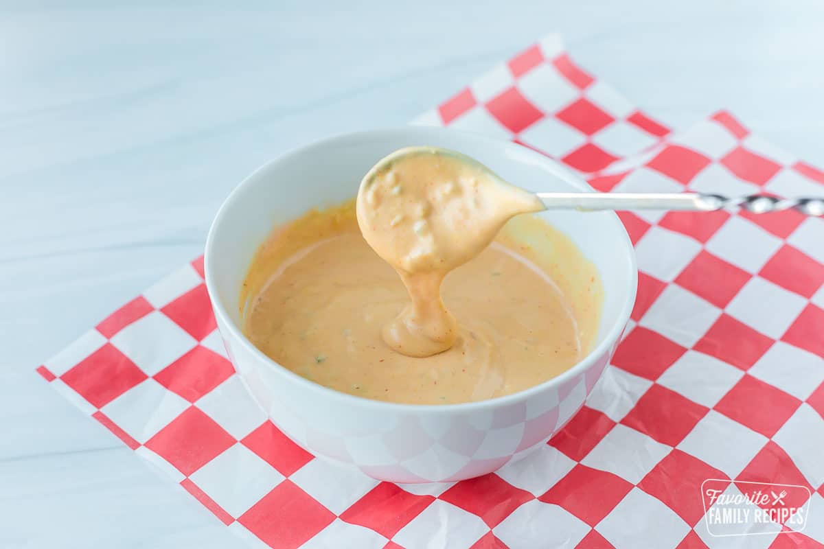 A spoon dripping with In-N-Out sauce