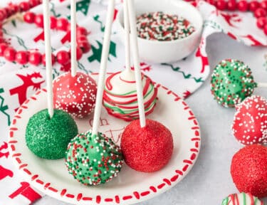 Plate of Christmas Cake Pops decorated with sprinkles.