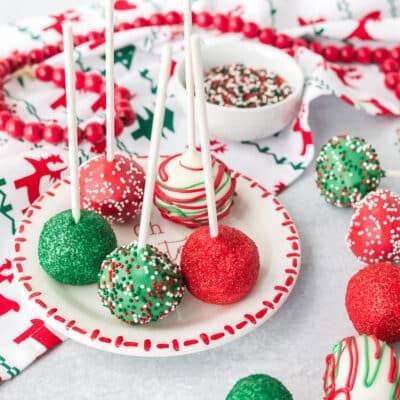 Plate of Christmas Cake Pops decorated with sprinkles.