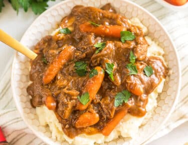 A bowl of beef goulash and mashed potatoes