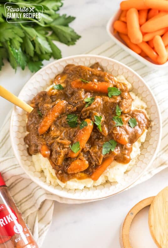 A bowl of beef goulash and mashed potatoes