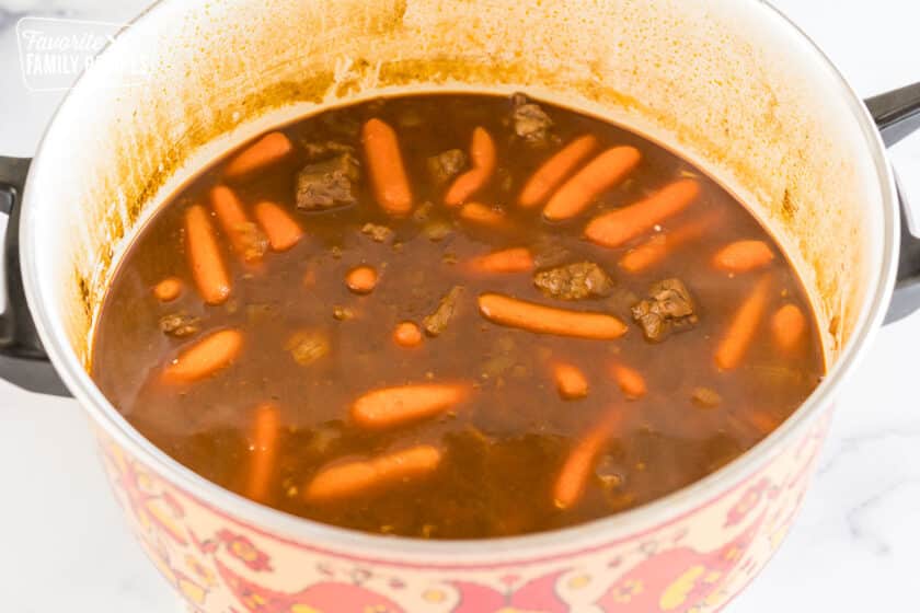 meat and carrots cooking in broth