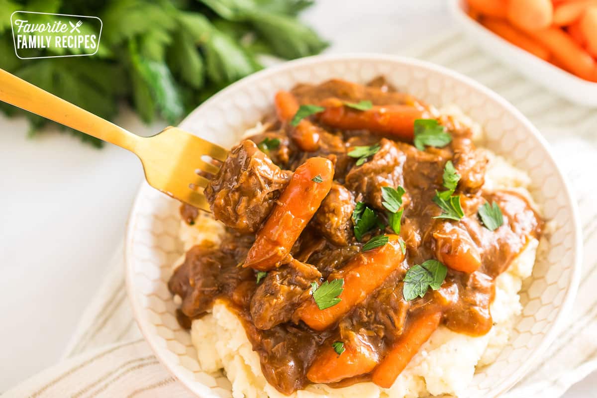 A bowl of beef goulash and mashed potatoes