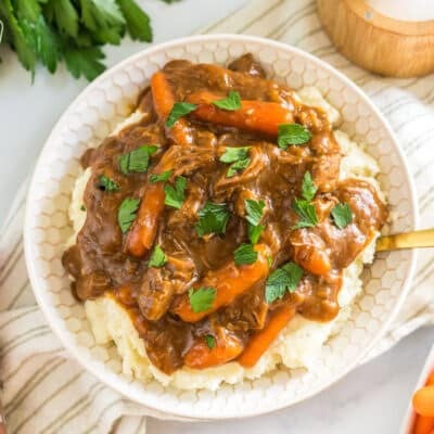 A bowl of beef goulash and mashed potatoes