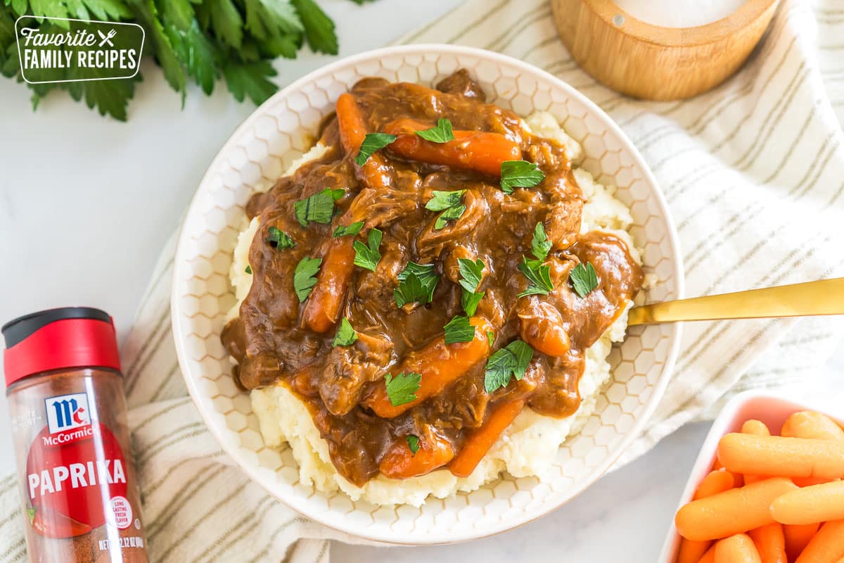 A bowl of beef goulash and mashed potatoes