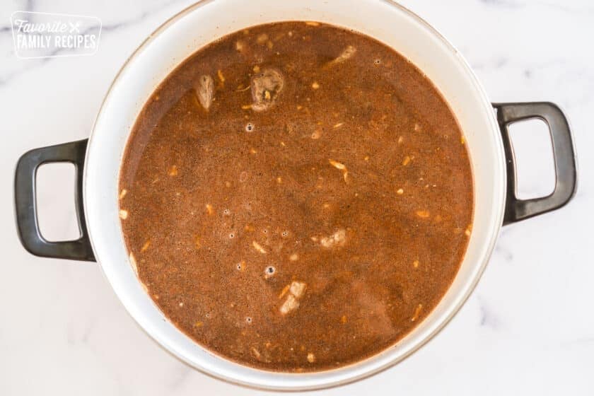 Beef simmering in liquid in a pot
