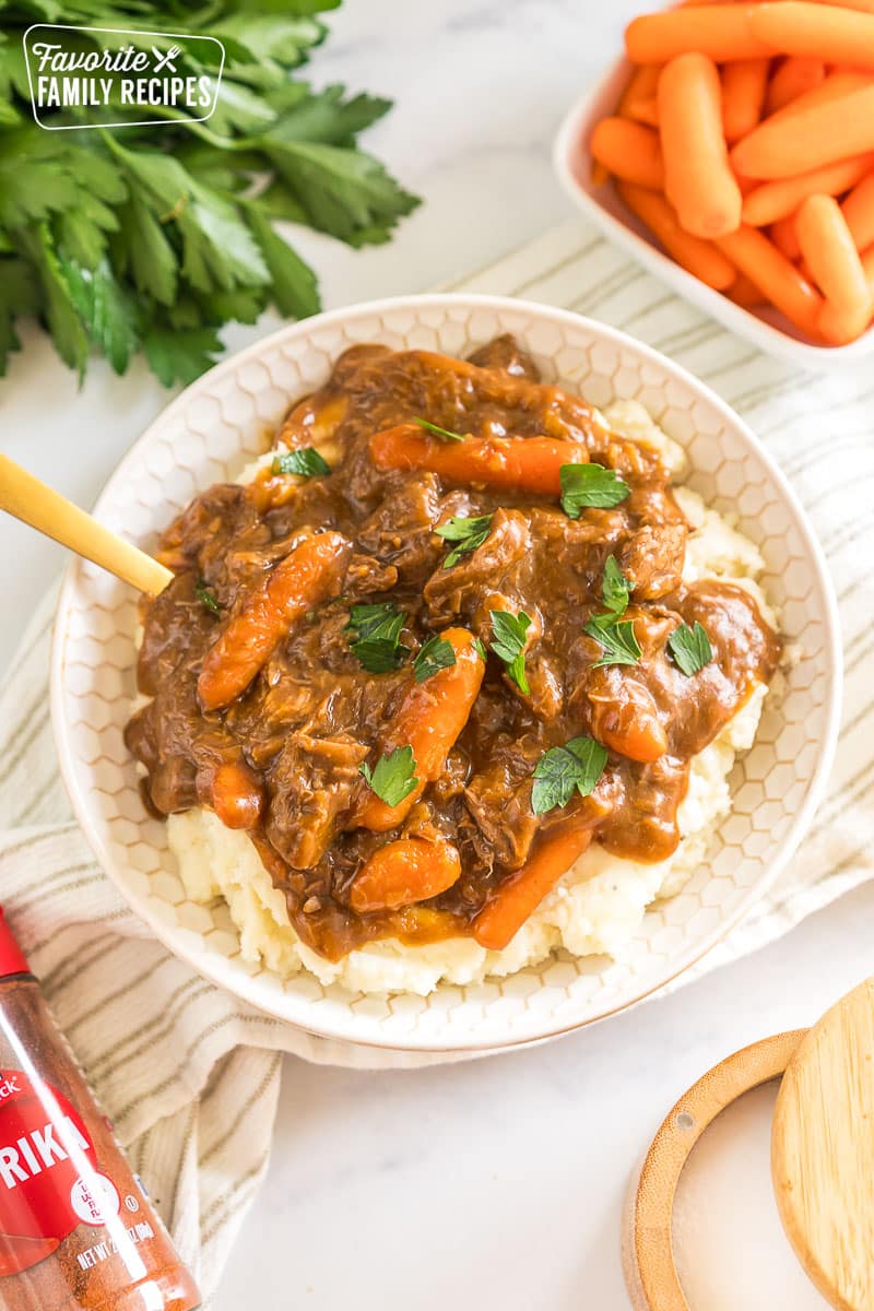 A bowl of beef goulash and mashed potatoes