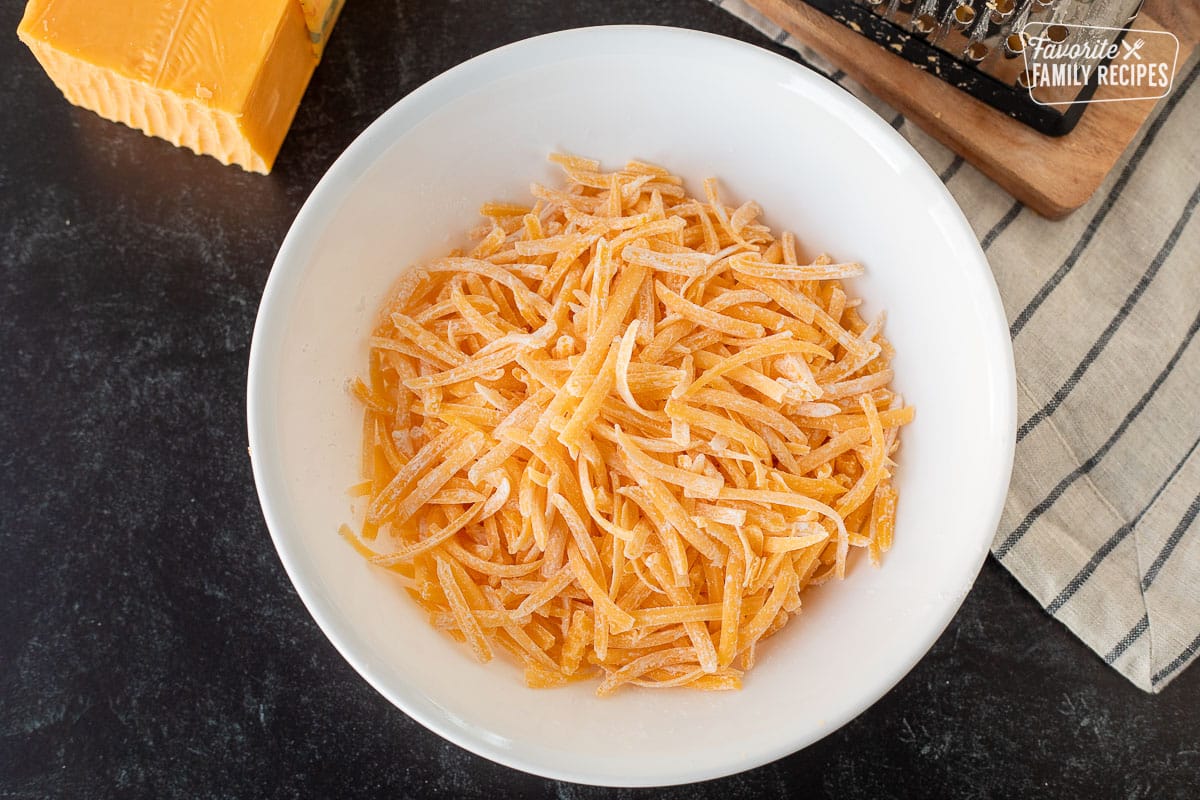 Corn starch combined with cheddar cheese in a bowl for freezing.
