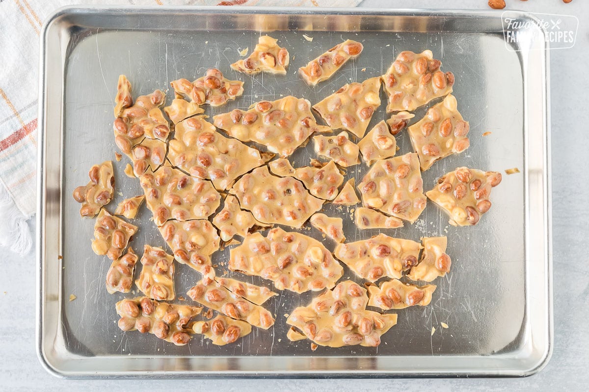 Cracked pieces of Peanut Brittle on a baking sheet.