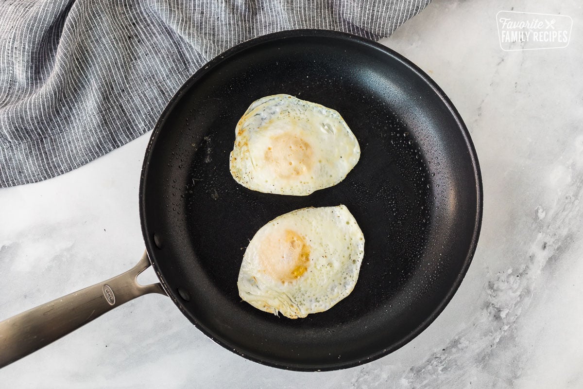 Two cooked eggs in skillet.