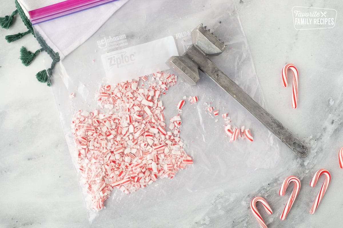 Ziplock bag with crushed candy canes and a metal kitchen mallet.