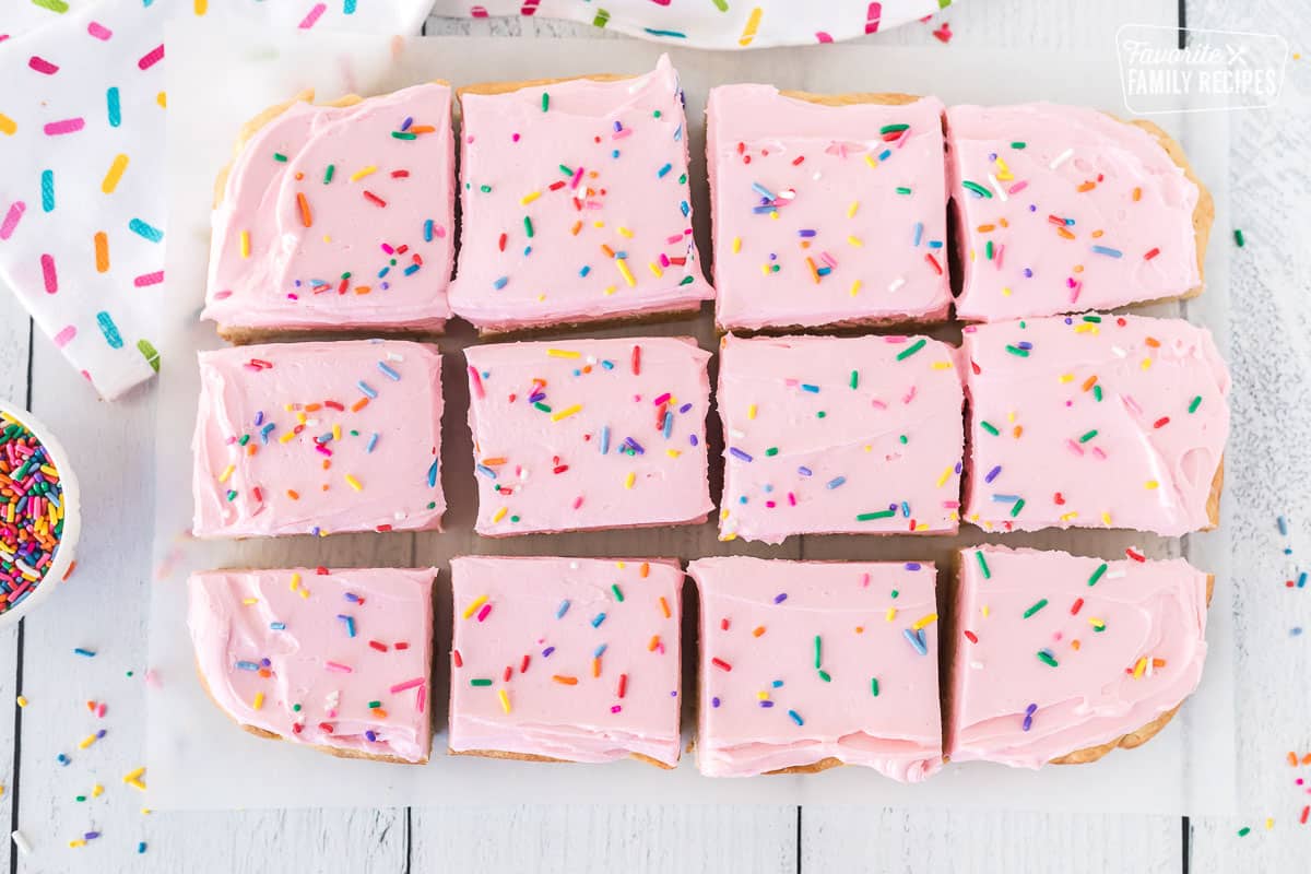 Cut Sugar Cookie Bars with pink frosting and sprinkles.