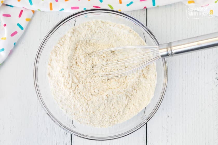 Mixing bowl with dry ingredients and whisk.