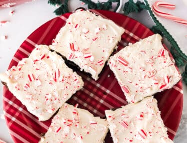 Plate with White Chocolate Peppermint Brownies and candy canes crushed on top.