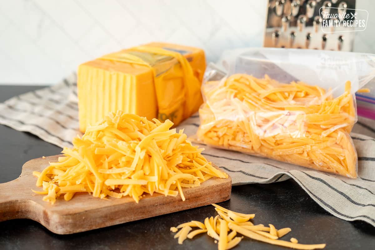 Bag of freeze cheese next to grater and grated cheddar cheese.