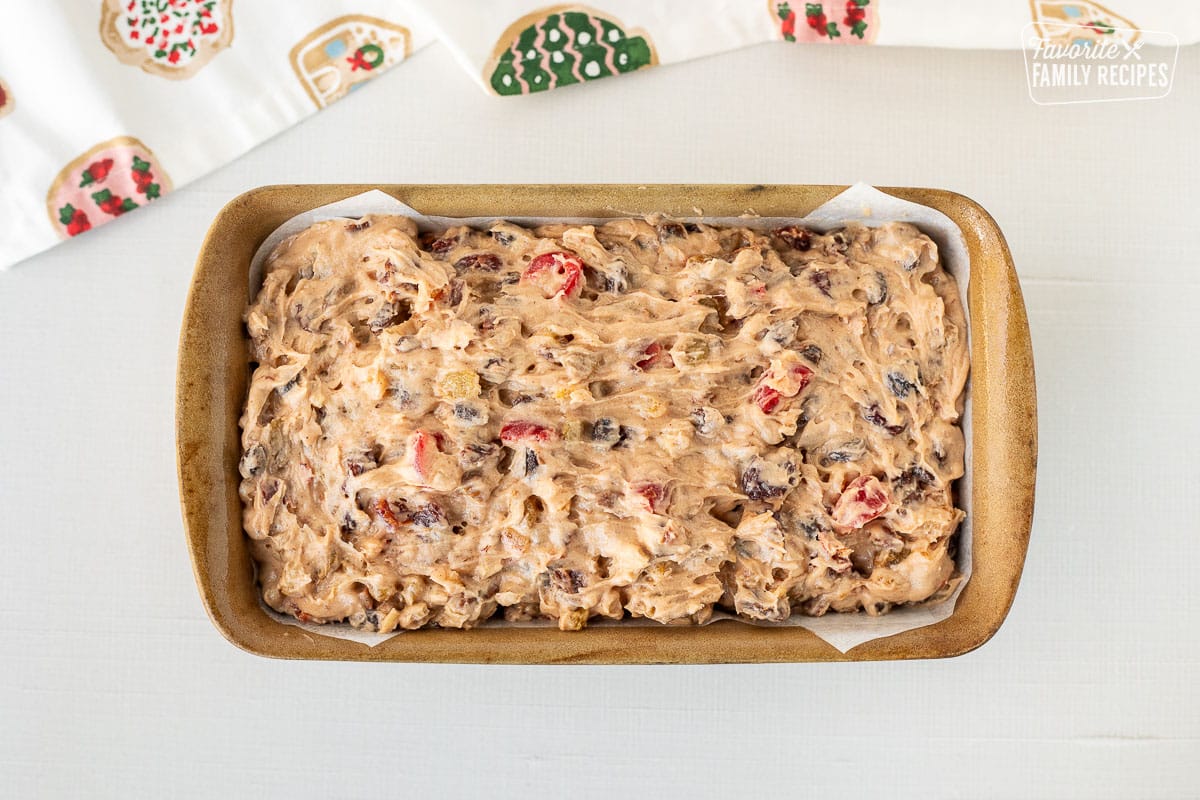 Unbaked Fruit Cake in a pan lined with parchment paper.