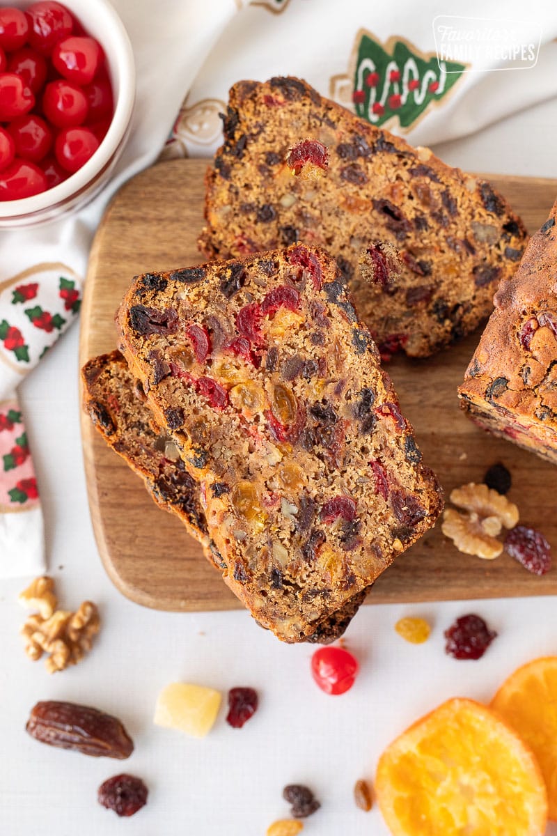 Two slices of stacked Fruit Cake next to a loaf.