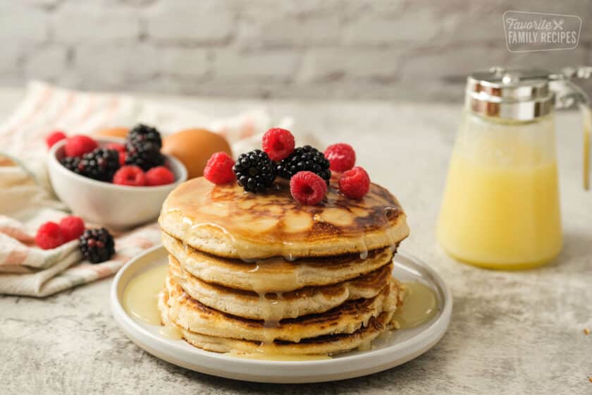Side view of stack of Gluten Free pancakes with syrup and berries