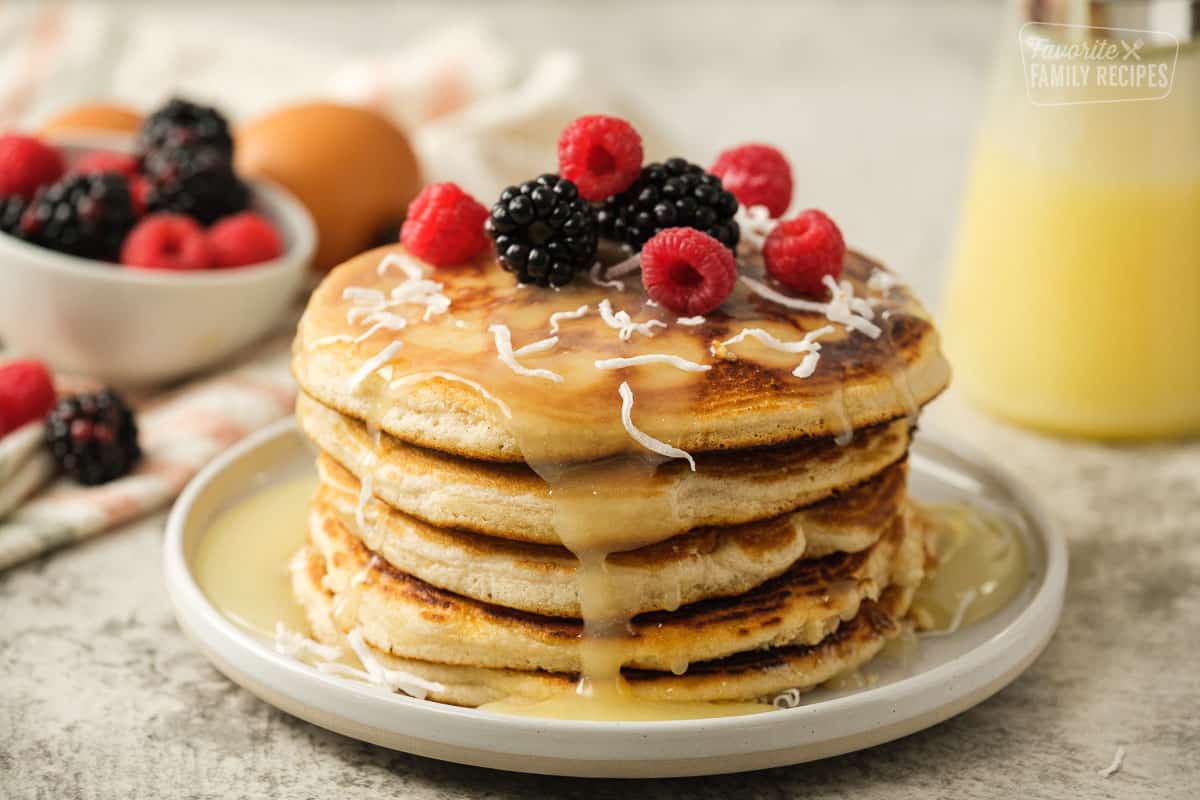 Side view of stack of Gluten Free pancakes with syrup and berries