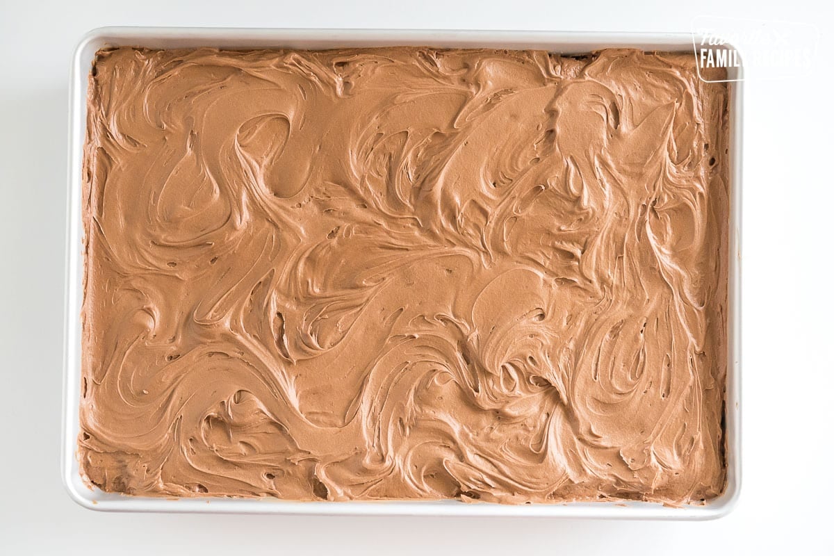 Vanilla cake with chocolate buttercream frosting in a baking dish.