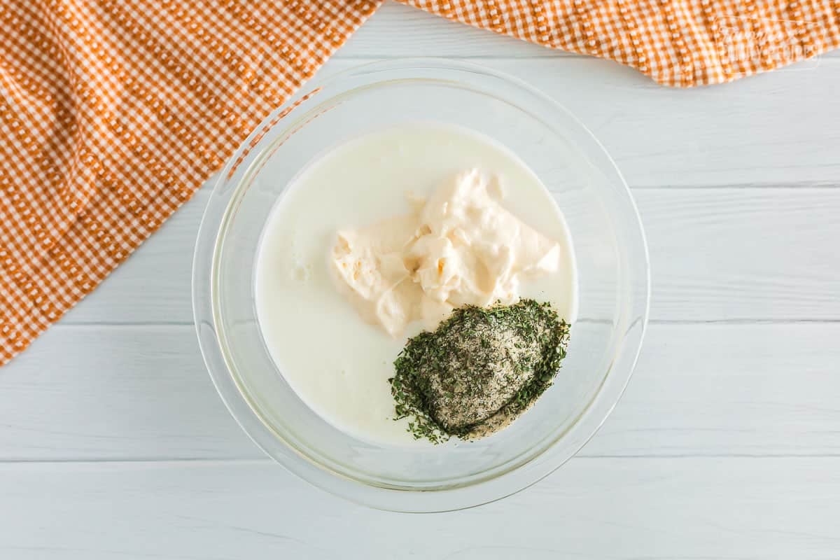 Homemade ranch dressing ingredients in a glass bowl.