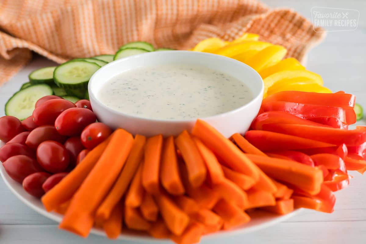 Homemade ranch dressing in the middle of sliced veggies. 