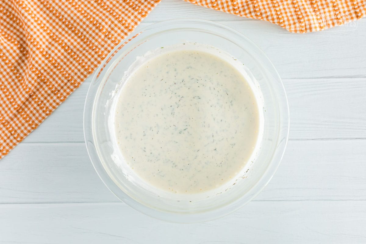 Homemade ranch dressing mixed together in a glass bowl.