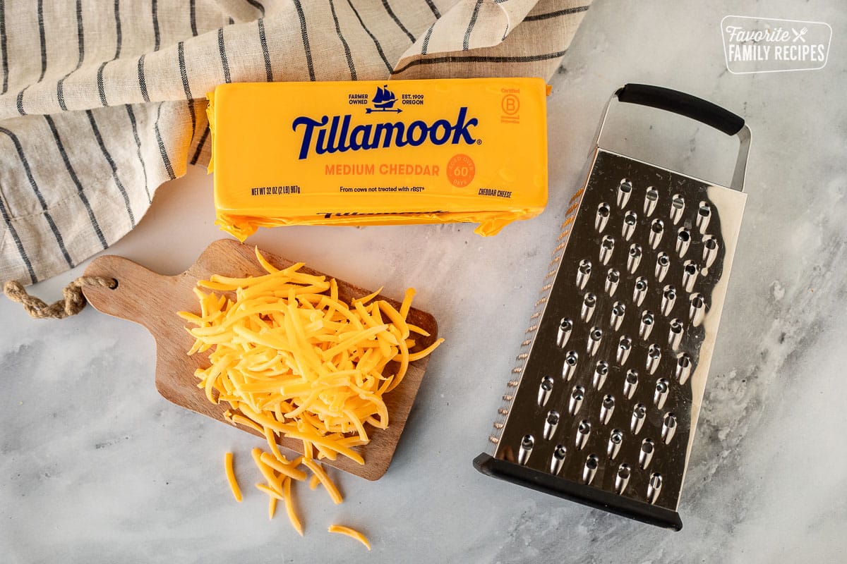 Ingredients to freeze cheese including a cheese grater and block of cheese.