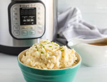 Instant pot mashed potatoes with a slice of butter sitting on top of the potatoes.