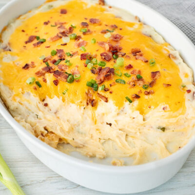 Casserole dish with scooped out areas from Loaded Mashed Potatoes.
