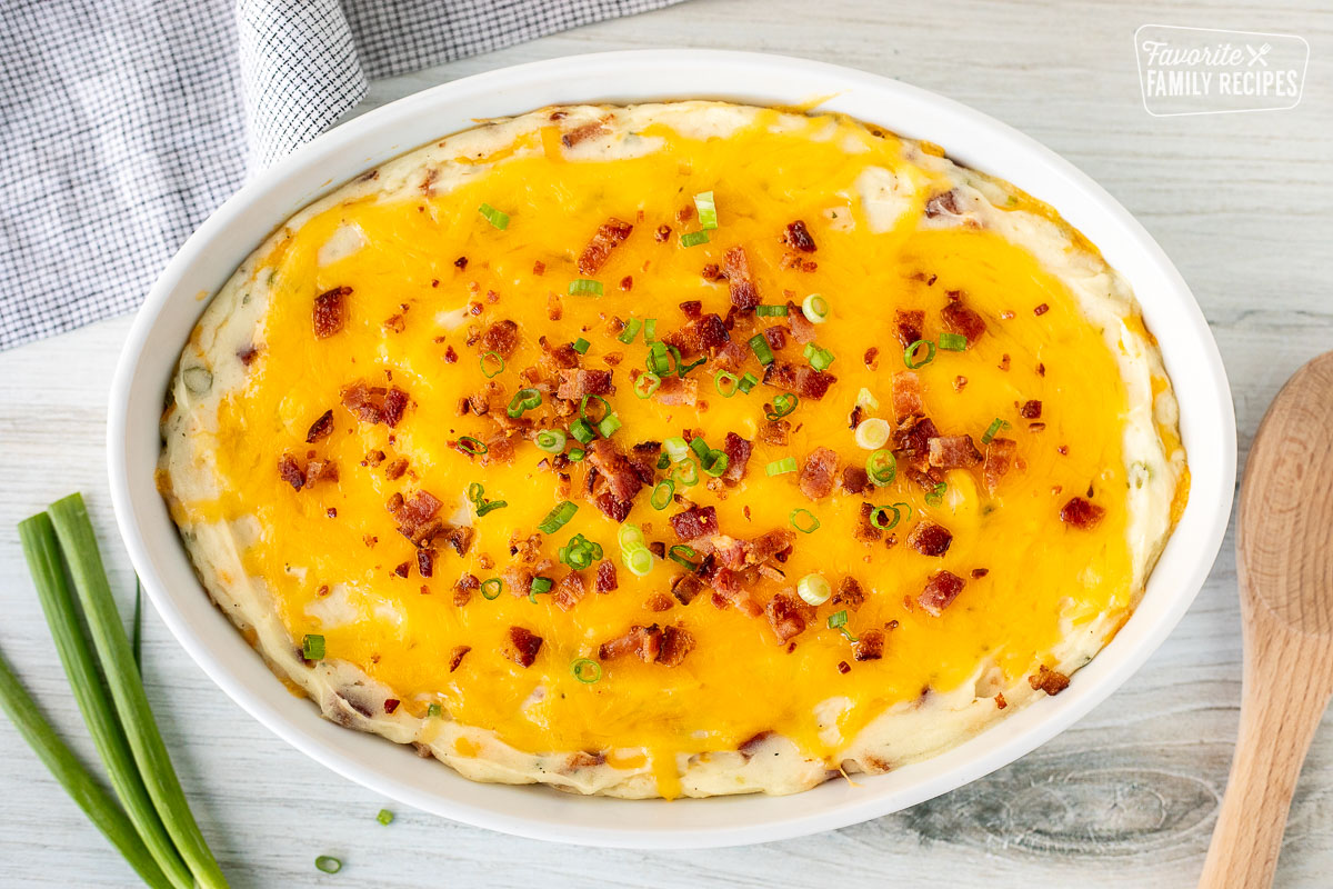 Baking dish of Loaded Mashed Potatoes with bacon and sliced green onions.