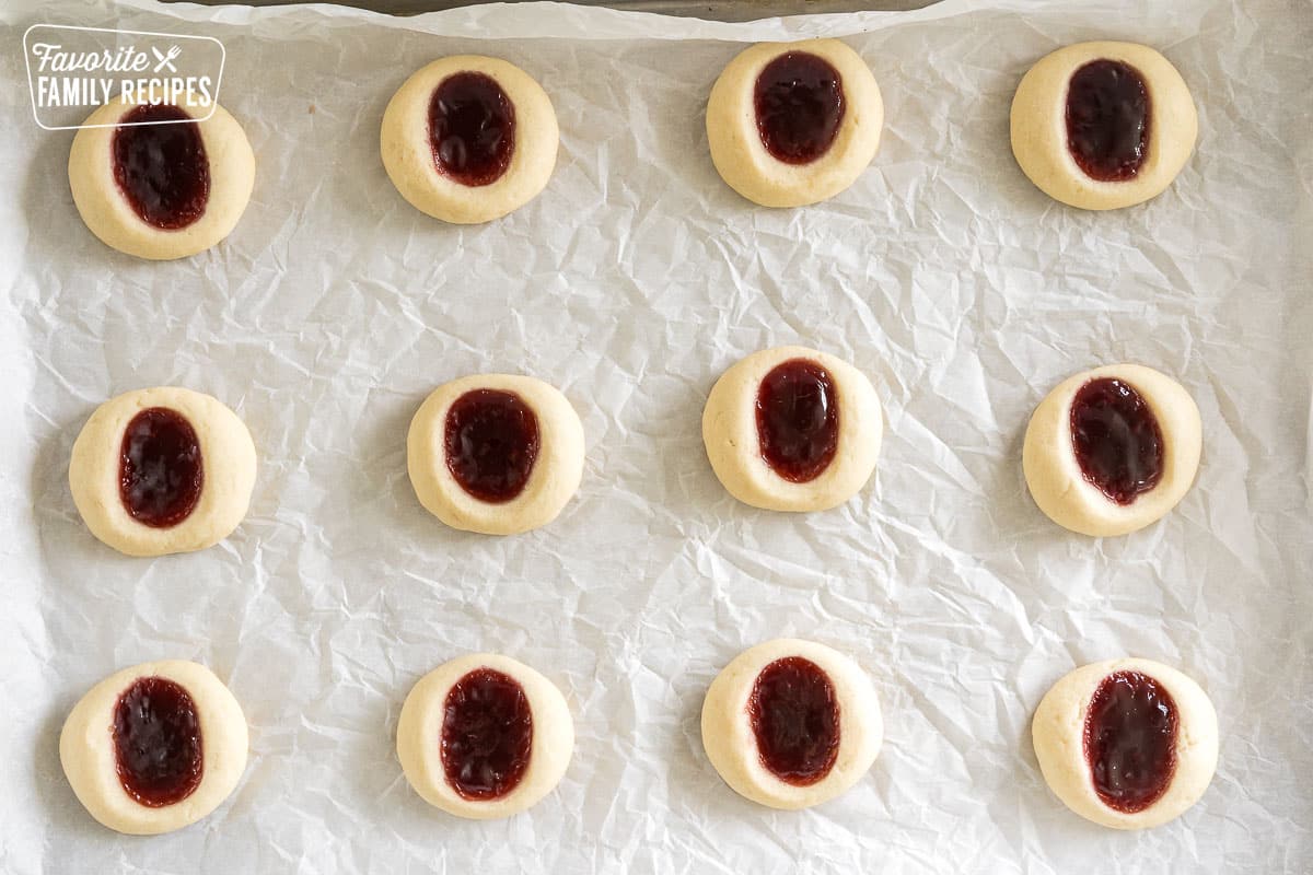 raspberry thumbprint cookies on a baking sheet