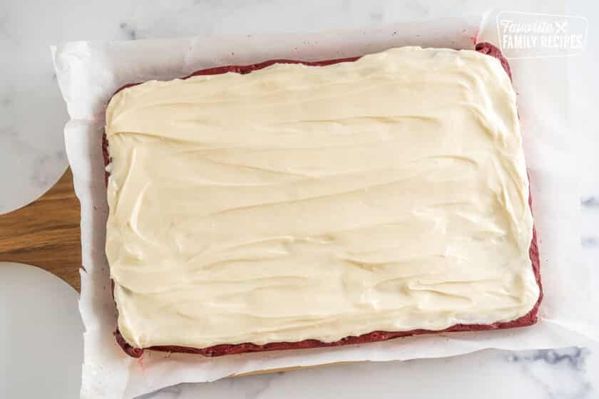 frosted red velvet brownies on a cutting board