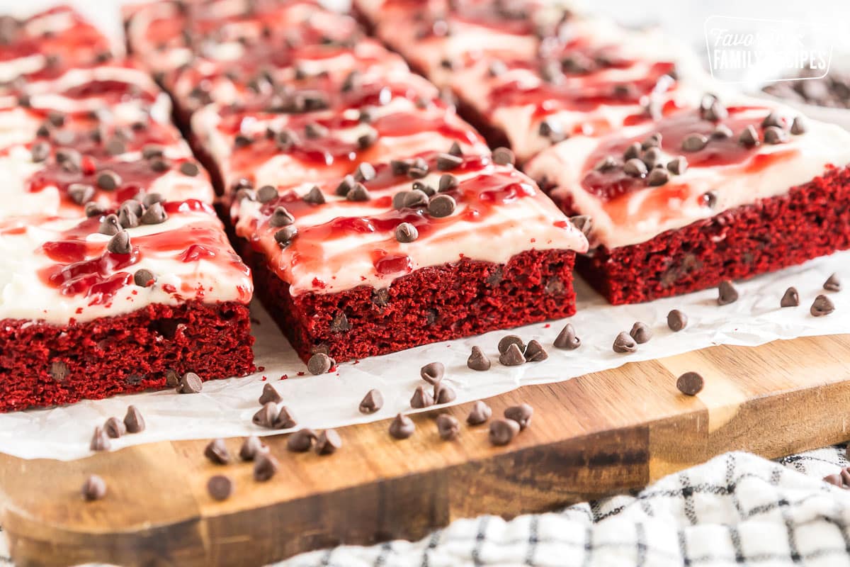 Red Velvet Brownies frosted with cream cheese icing and topped with raspberry topping and chocolate chips