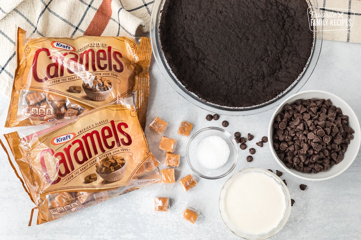 Ingredients to make Salted Caramel Pie including Oreo pie crust, chocolate chips, salt, cream and caramels.