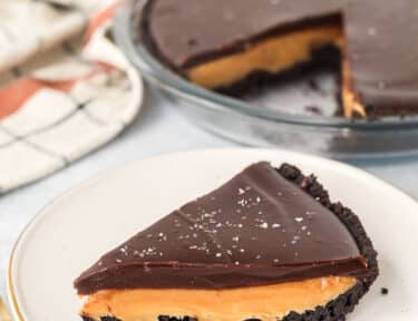 Slice of Salted Caramel Pie on a plate with a fork on the side.
