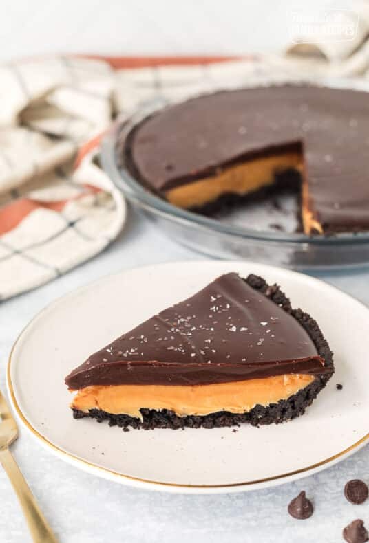 Slice of Salted Caramel Pie on a plate with a fork on the side.